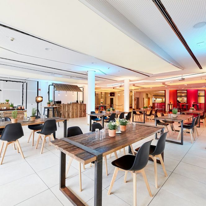 Bestuhlung mit Holztischen und dunklen Stühlen für einen Lunch in der Eingangshalle der Stadthalle Mülheim