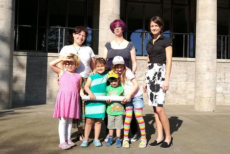 Kita-Kinder an der Stadthalle – sie bekommen alte Plakate der Stadthalle Mülheim zum Bemalen